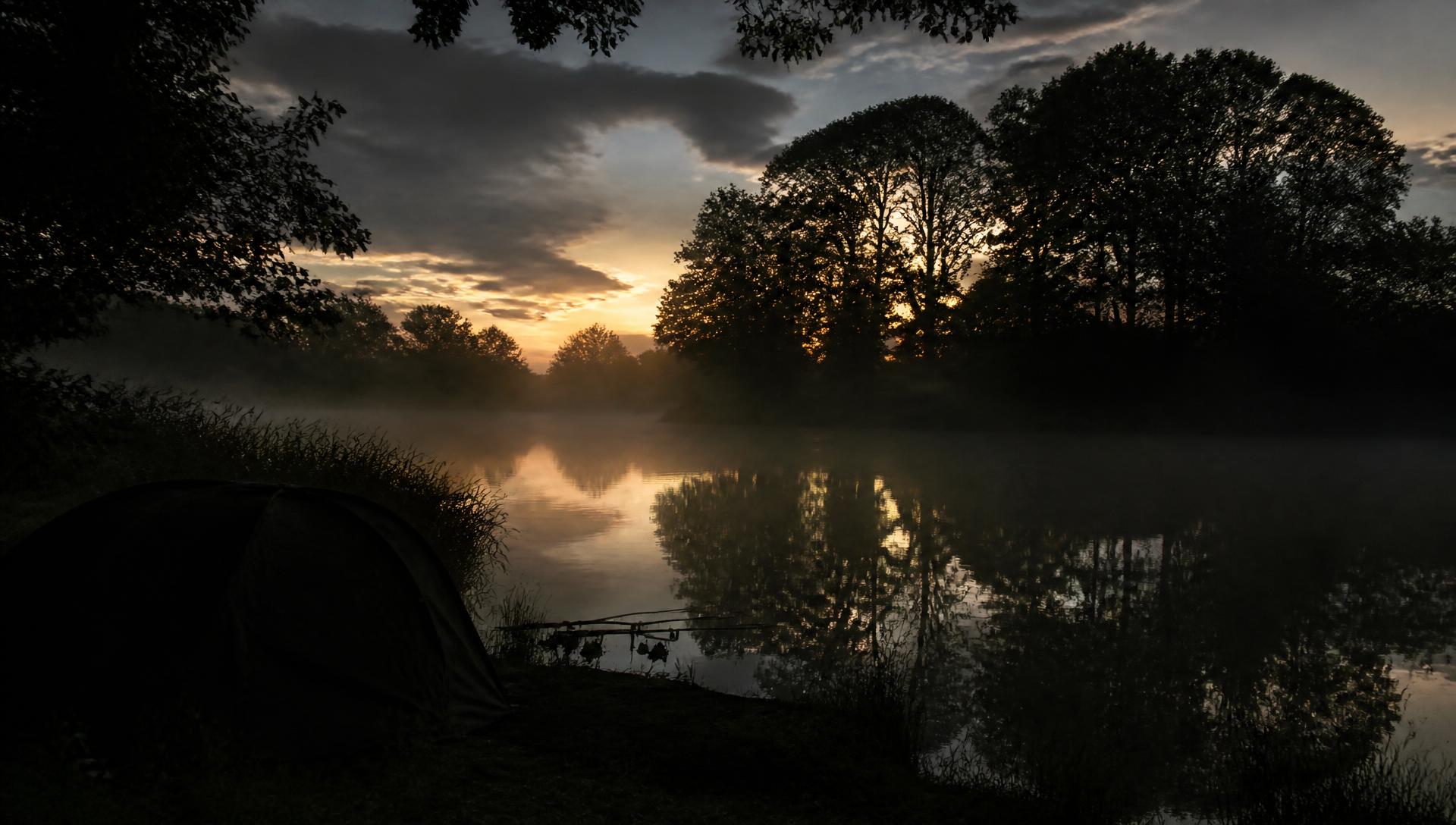 English carp lake at dusk with mist over dark water